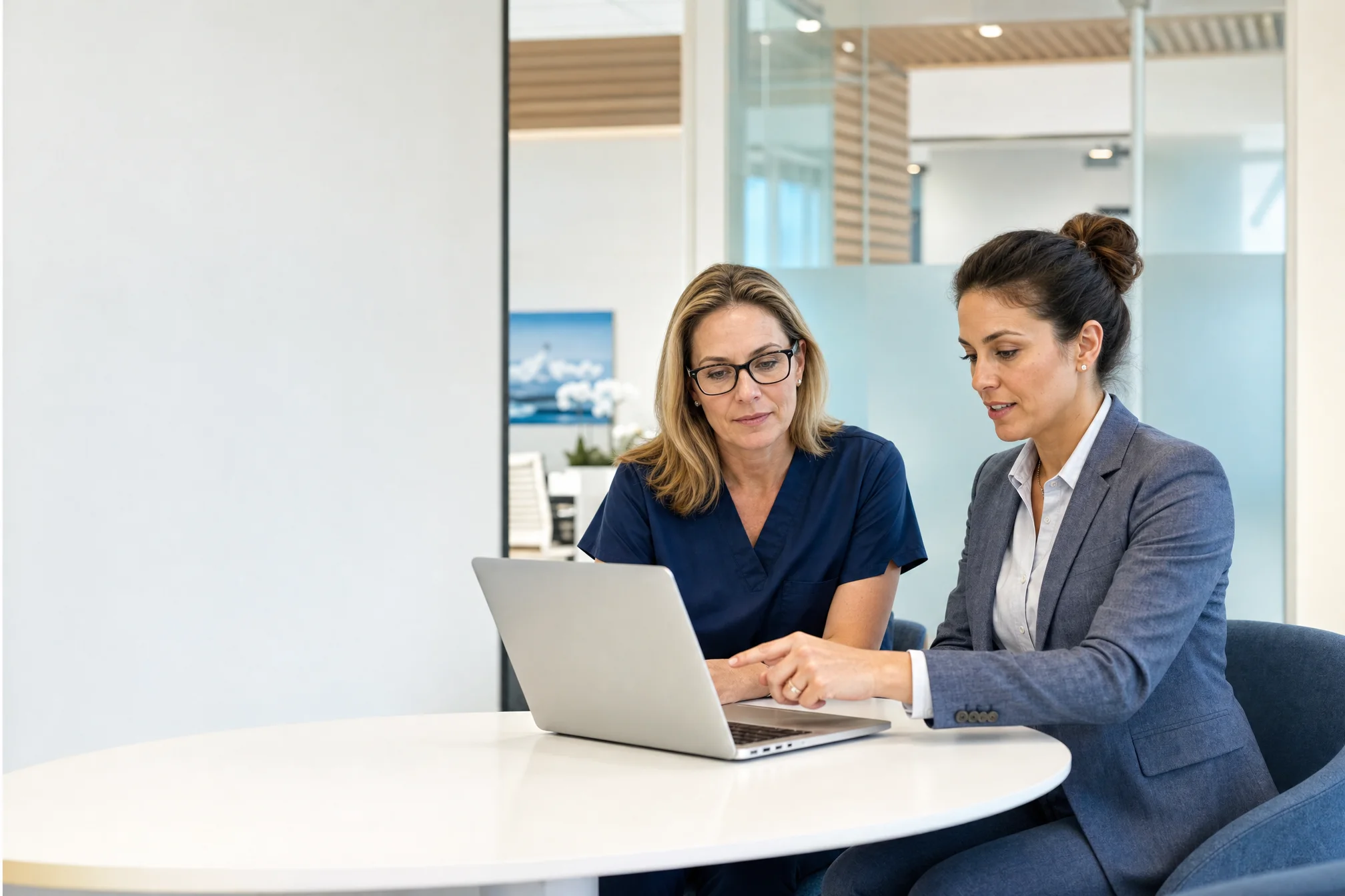 Illustrative scene of a clinical professional and an advisor discussing a practice workflow at a laptop.